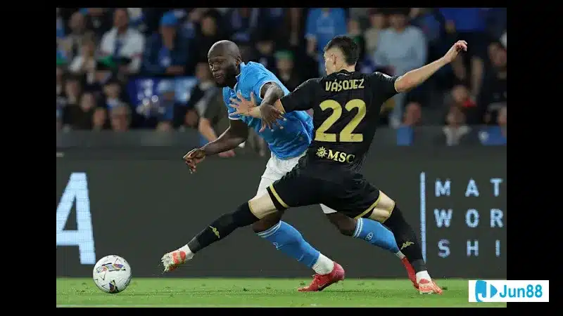 Cầu thủ Napoli điều chỉnh bóng trước sự áp sát của cầu thủ Genoa trên sân